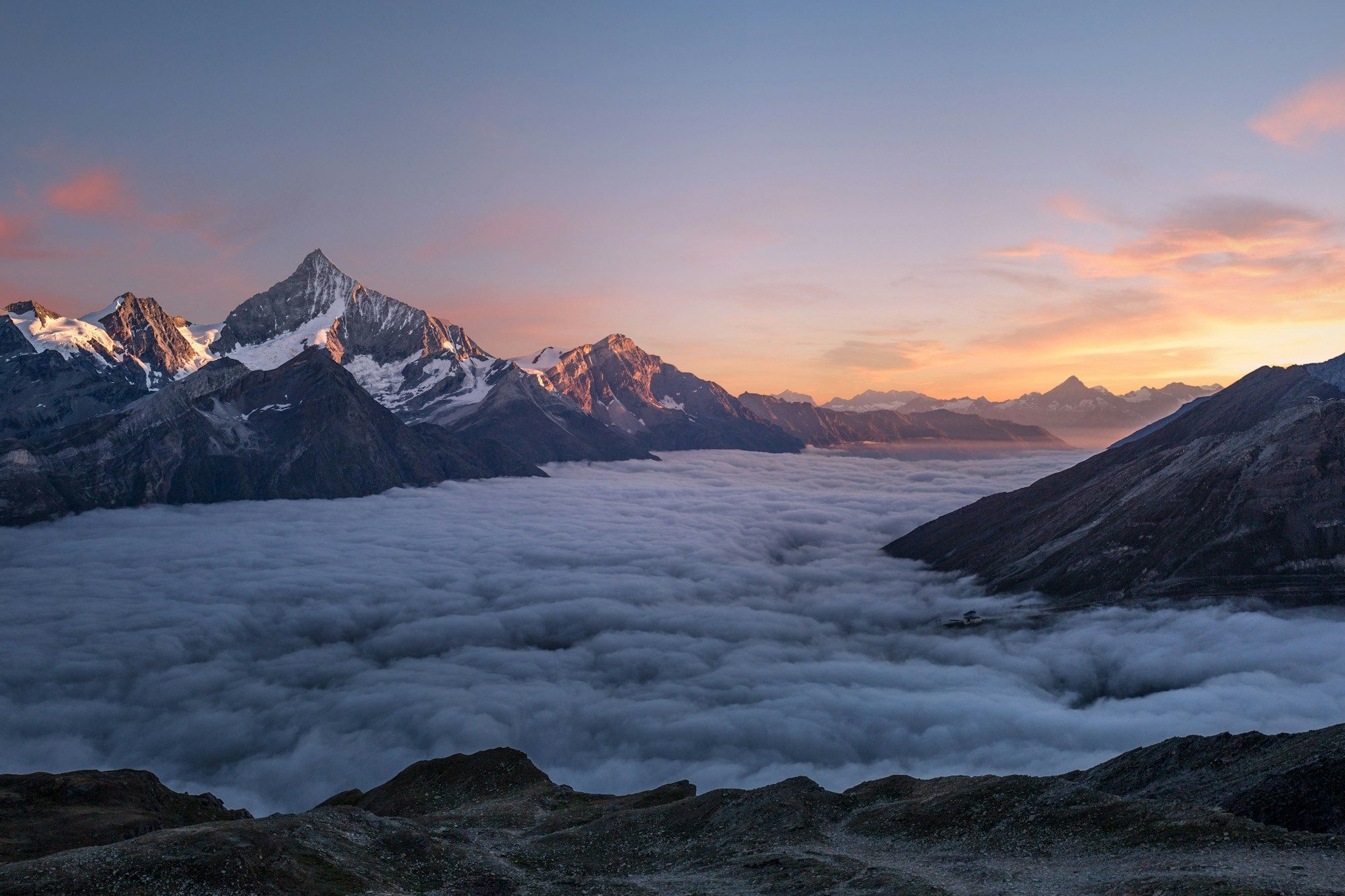Sunlit mountain peaks under a soft evening sky.